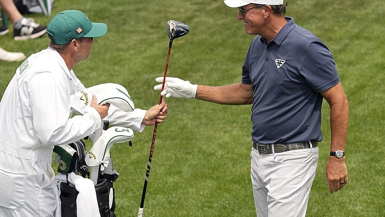 Apr 7, 2023; Augusta, Georgia, USA; Phil Mickelson hands his driver to caddie Tim Mickelson on the 18th tee box during the second round of The Masters golf tournament. Mandatory Credit: Michael Madrid-USA TODAY Network