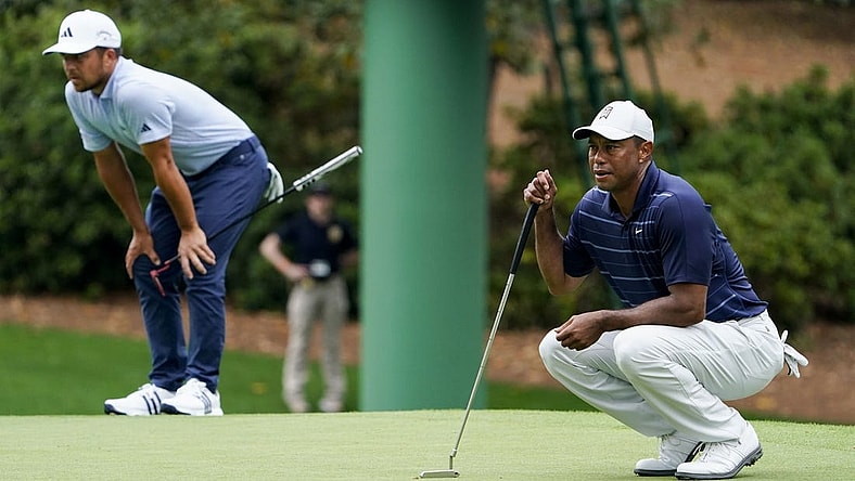 Apr 7, 2023; Augusta, Georgia, USA; Xander Schauffele and Tiger Woods line up putts on the tenth green during the second round of The Masters golf tournament. Mandatory Credit: Danielle Parhizkaran-USA TODAY Network