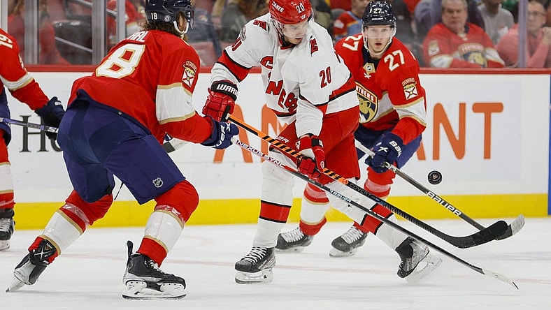 Apr 13, 2023; Sunrise, Florida, USA; Carolina Hurricanes center Sebastian Aho (20) controls the puck against Florida Panthers defenseman Marc Staal (18) and center Eetu Luostarinen (27) during the first period at FLA Live Arena. Mandatory Credit: Sam Navarro-USA TODAY Sports