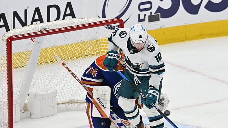 Apr 13, 2023; Edmonton, Alberta, CAN;   Edmonton Oilers goalie Stuart Skinner (74) battles for the puck with  San Jose Sharks left winger Evgeny Svechnikov (10) during the first period at Rogers Place. Mandatory Credit: Walter Tychnowicz-USA TODAY Sports