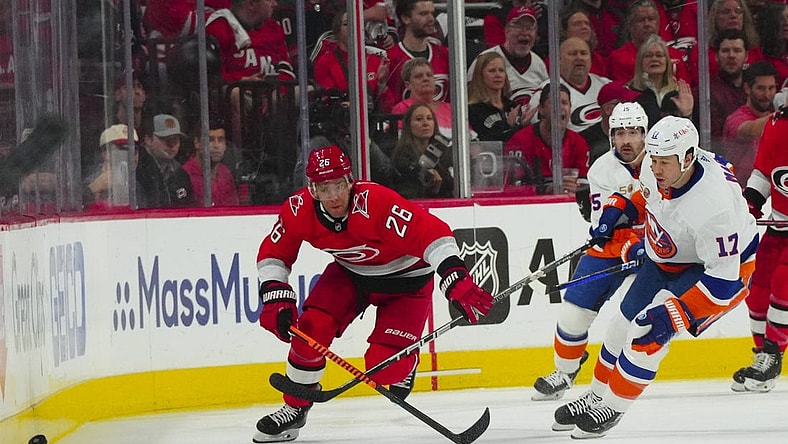 Apr 19, 2023; Raleigh, North Carolina, USA; Carolina Hurricanes center Paul Stastny (26) and New York Islanders left wing Matt Martin (17) chase after the puck during the first period in game two of the first round of the 2023 Stanley Cup Playoffs at PNC Arena. Mandatory Credit: James Guillory-USA TODAY Sports