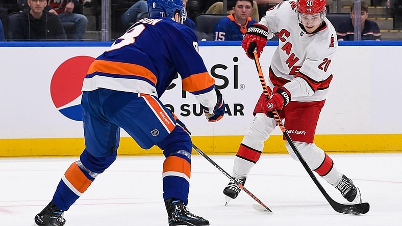 Apr 21, 2023; Elmont, New York, USA; Carolina Hurricanes center Sebastian Aho (20) attempts a shot defended by New York Islanders defenseman Noah Dobson (8) during the first period in game three of the first round of the 2023 Stanley Cup Playoffs at UBS Arena. Mandatory Credit: Dennis Schneidler-USA TODAY Sports