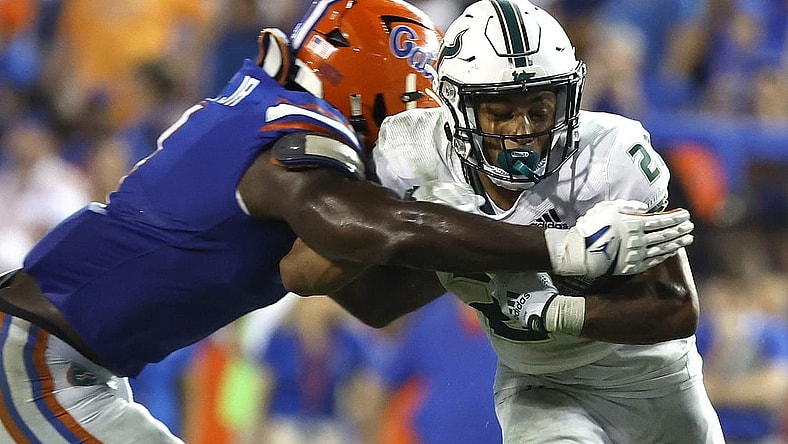 Sep 17, 2022; Gainesville, Florida, USA; South Florida Bulls running back Michel Dukes (2) runs with the ball as Florida Gators linebacker Brenton Cox Jr. (1) defends during the second half at Ben Hill Griffin Stadium. Mandatory Credit: Kim Klement-USA TODAY Sports