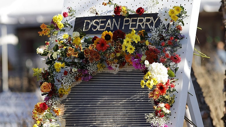 Nov 19, 2022; Charlottesville, Virginia, US; A partial view of a flower board with an image of D'Sean Perry, one of three Virginia Cavaliers football players killed in a campus shooting on November 13th is displayed prior to the start of a memorial at John Paul Jones Arena. Mandatory Credit: Geoff Burke-USA TODAY Sports