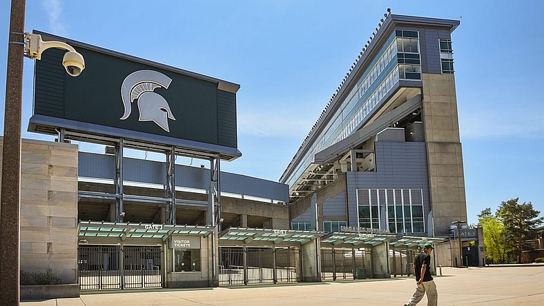 A passerby walks past a camera mounted outside the north entrance of Spartan Stadium, Wednesday, May 10, 2023.