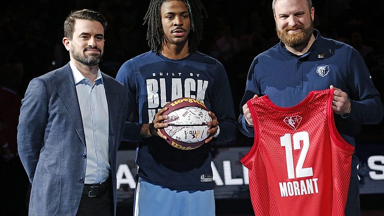 Feb 16, 2022; Memphis, Tennessee, USA; Memphis Grizzles guard Ja Morant (middle) receives a memorial game ball and jersey from general manager Zach Kleiman (left) and head coach Taylor Jenkins, for being selected to the All-Star Game, at FedExForum. Mandatory Credit: Petre Thomas-USA TODAY Sports