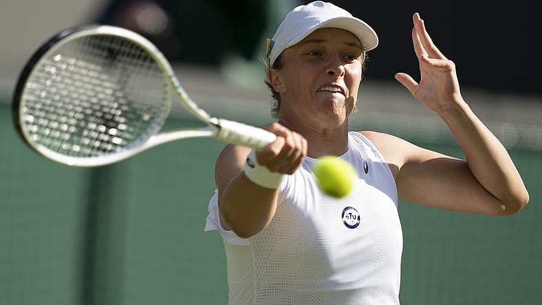 Jun 30, 2022; London, United Kingdom; Iga Swiatek (POL) returns a shot during her match against Lesley Pattinama Kerkhove (NED) on day four at All England Lawn Tennis and Croquet Club. Mandatory Credit: Susan Mullane-USA TODAY Sports