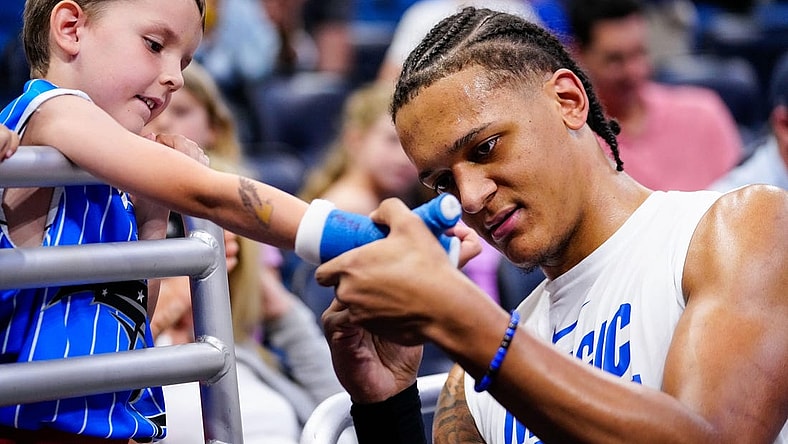 Apr 2, 2023; Orlando, Florida, USA;  Orlando Magic forward Paolo Banchero (5) signs a fans cast prior to a game against the Detroit Pistons at Amway Center. Mandatory Credit: Rich Storry-USA TODAY Sports