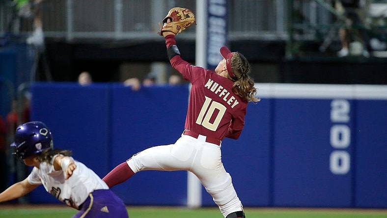 Florida State's Josie Muffley (10) makes a line drive catch behind Washington's Megan Vandegrift (2) in the seventh inning during a softball game between Washington and Florida State in the Women's College World Series at USA Softball Hall of Fame Stadium in  in Oklahoma City, Saturday, June, 3, 2023.