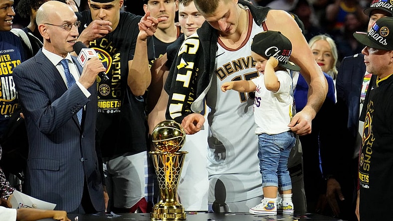 Jun 12, 2023; Denver, Colorado, USA; Denver Nuggets center Nikola Jokic (15) and his daughter point to the Bill Russell NBA Finals MVP Award trophy after winning the 2023 NBA Finals against the Miami Heat at Ball Arena. Mandatory Credit: Kyle Terada-USA TODAY Sports