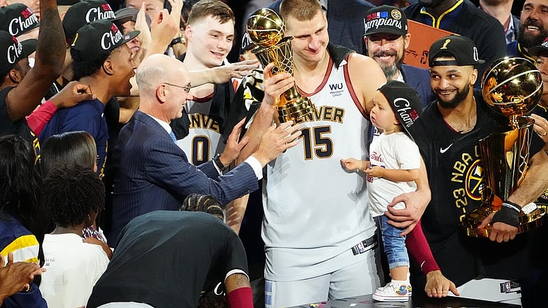 Jun 12, 2023; Denver, Colorado, USA; NBA commissioner Adam Silver presents the Bill Russell NBA Finals MVP Award to Denver Nuggets center Nikola Jokic (15) as Jokic holds his daughter Ognjena Jokic after the Nuggets won the 2023 NBA Championship against the Miami Heat at Ball Arena. Looking on is Denver guard Jamal Murray (27) holds the Larry O'Brien Trophy. Mandatory Credit: Ron Chenoy-USA TODAY Sports