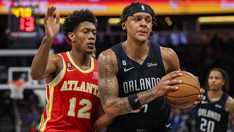 Dec 14, 2022; Orlando, Florida, USA;  Atlanta Hawks forward De'Andre Hunter (12) guards Orlando Magic forward Paolo Banchero (5) in the fourth quarter at Amway Center. Mandatory Credit: Nathan Ray Seebeck-USA TODAY Sports