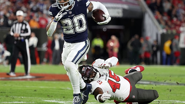 Jan 16, 2023; Tampa, Florida, USA; Dallas Cowboys running back Tony Pollard (20) breaks the tackle of Tampa Bay Buccaneers linebacker Devin White (45) in the first half during the wild card game at Raymond James Stadium. Mandatory Credit: Kim Klement-USA TODAY Sports
