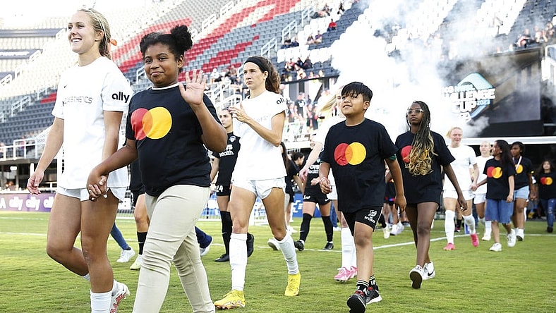 Jun 14, 2023; Washington, D.C., USA; Young fans walk with the North Carolina Courage  before ether match against the Washington Spirit at Audi Field. Mandatory Credit: Amber Searls-USA TODAY Sports