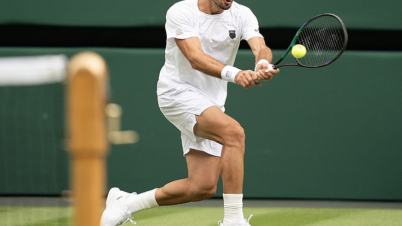 Jul 3, 2023; London, United Kingdom;  Pedro Cachin (ARG) returns the ball during his match against Novak Djokovic (SRB) on day one of the Wimbledon championships at the All England Lawn Tennis and Croquet Club. Mandatory Credit: Susan Mullane-USA TODAY Sports