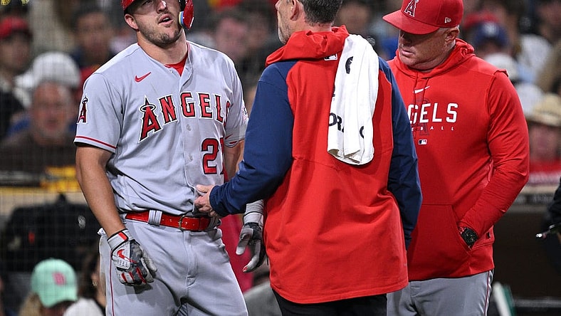 Jul 3, 2023; San Diego, California, USA; Los Angeles Angels center fielder Mike Trout (27) is checked by a trainer after an injury sustained during an at-bat in the eighth inning against the San Diego Padres at Petco Park. Mandatory Credit: Orlando Ramirez-USA TODAY Sports