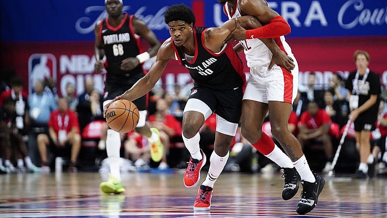 Jul 7, 2023; Las Vegas, NV, USA;  Portland Trail Blazers guard Scoot Henderson (00) dribbles the ball against Houston Rockets guard/forward Nate Hinton (62) during the first half at Thomas & Mack Center. Mandatory Credit: Lucas Peltier-USA TODAY Sports
