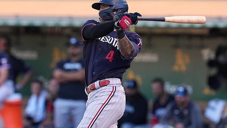 Jul 15, 2023; Oakland, California, USA; Minnesota Twins shortstop Carlos Correa (4) hits a double against the Oakland Athletics during the eighth inning at Oakland-Alameda County Coliseum. Mandatory Credit: Darren Yamashita-USA TODAY Sports