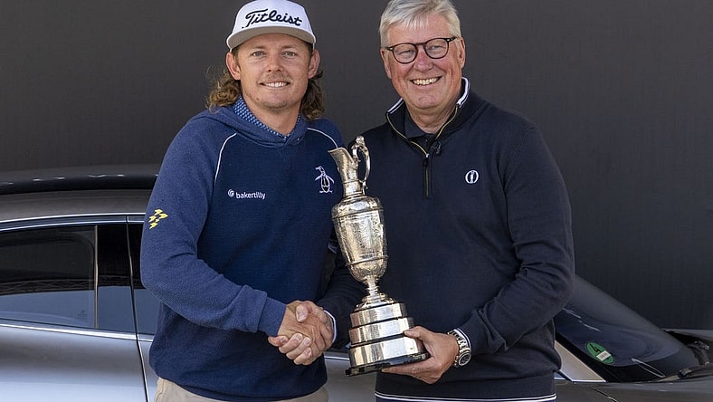 July 17, 2023; Hoylake, ENGLAND, GBR; 2022 winner Cameron Smith (left) arrives with the Claret Jug Trophy and poses with R&A chief executive Martin Slumbers (right) during a practice round of The Open Championship golf tournament at Royal Liverpool. Mandatory Credit: Kyle Terada-USA TODAY Sports