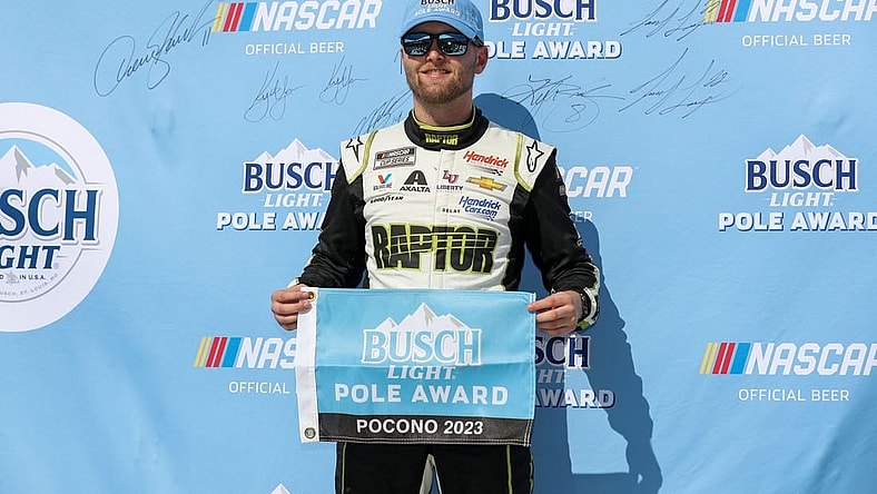 Jul 22, 2023; Long Pond, Pennsylvania, USA; NASCAR Cup Series driver William Byron stands with the Busch Light Pole Award after winning the pole for the HighPoint.com 400 at Pocono Raceway. Mandatory Credit: Matthew O'Haren-USA TODAY Sports