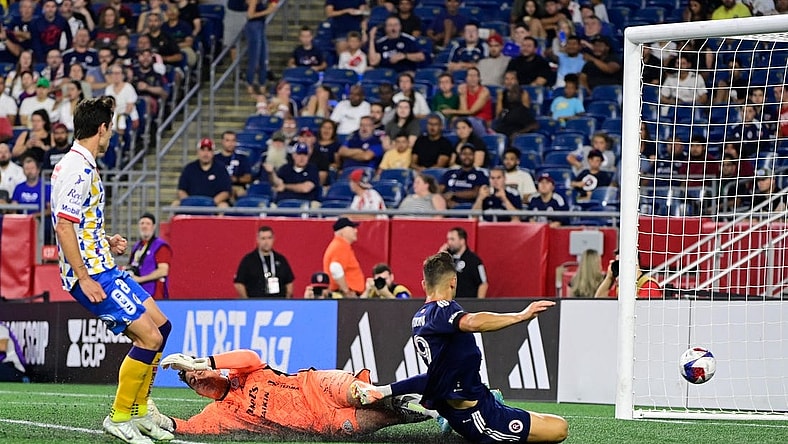 Jul 26, 2023; Foxborough, MA, USA; New England Revolution forward Giacomo Vrioni (9) scores a goal on Club Atletico de San Luis goalkeeper Andres Sanchez (1)  during the second half at Gillette Stadium. Mandatory Credit: Eric Canha-USA TODAY Sports