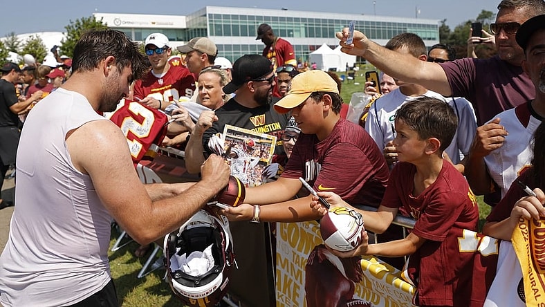 Jul 28, 2023; Ashburn, VA, USA; Washington Commanders quarterback Sam Howell (L) signs autographs after morning practice on day three of Commanders training camp at OrthoVirginia Training Center. Mandatory Credit: Geoff Burke-USA TODAY Sports