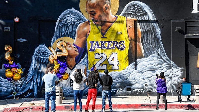 Jan 26, 2021; Los Angeles, California, USA; Fans gather at a mural of Kobe Bryant and his daughter Gianna painted on the wall of Hardcore Fitness Bootcamp gym in downtown Los Angeles. Bryant and his daughter and seven other persons died in a helicopter crash in Calabasas, Calif. on Jan. 26, 2020. Mandatory Credit: Robert Hanashiro-USA TODAY Sports