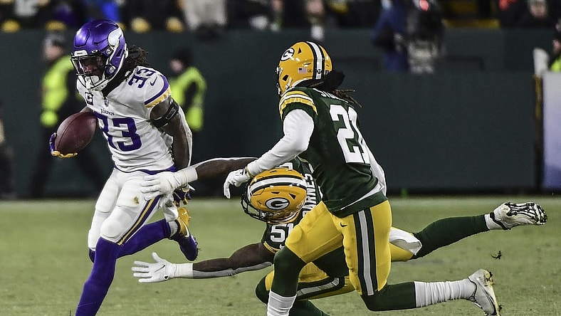 Jan 2, 2022; Green Bay, Wisconsin, USA; Minnesota Vikings running back Dalvin Cook (33) tries to break a tackle by Green Bay Packers linebacker Krys Barnes (51) in the first quarter at Lambeau Field. Mandatory Credit: Benny Sieu-USA TODAY Sports