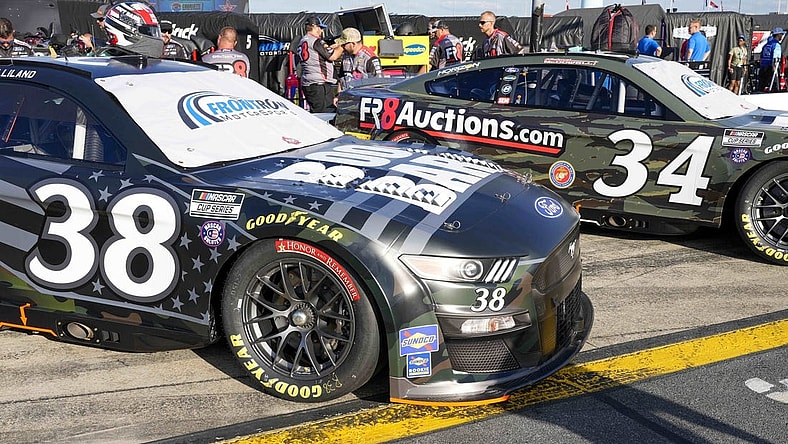 May 28, 2022; Concord, North Carolina, USA; The cars of NASCAR Cup Series driver Todd Gilliland (38) and driver Michael McDowell (34) sport military color schemes during Nascar Cup Practice at Charlotte Motor Speedway. Mandatory Credit: Jim Dedmon-USA TODAY Sports