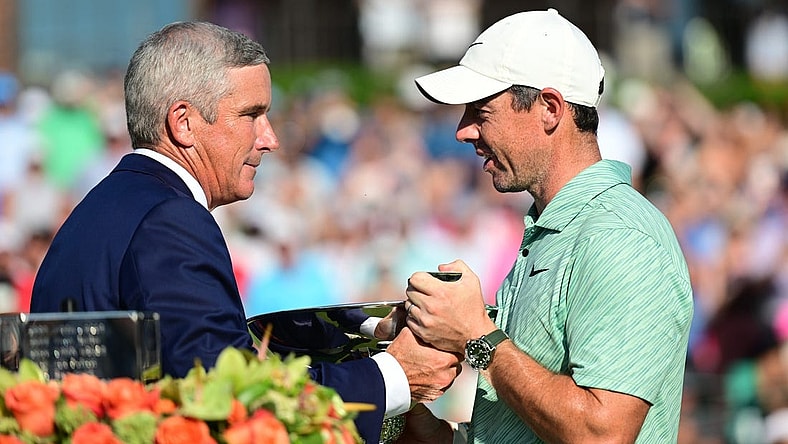 Aug 28, 2022; Atlanta, Georgia, USA; PGA commissioner Jay Monahan hands the FedEx Cup trophy to Rory McIlroy during the final round of the TOUR Championship golf tournament. Mandatory Credit: Adam Hagy-USA TODAY Sports