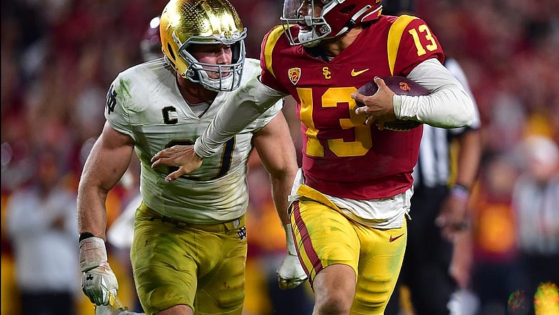 Nov 26, 2022; Los Angeles, California, USA; Southern California Trojans quarterback Caleb Williams (13) runs the ball ahead of Notre Dame Fighting Irish linebacker JD Bertrand (27)  during the second half at the Los Angeles Memorial Coliseum. Mandatory Credit: Gary A. Vasquez-USA TODAY Sports