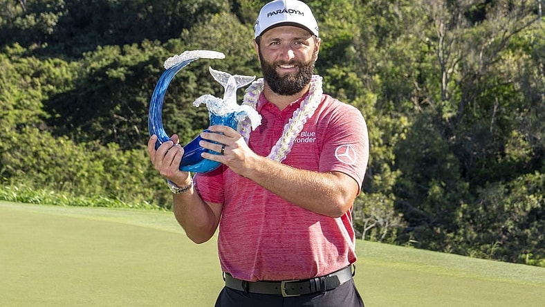 January 8, 2023; Maui, Hawaii, USA; Jon Rahm hoists the trophy on the 18th hole during the final round of the Sentry Tournament of Champions golf tournament at Kapalua Resort - The Plantation Course. Mandatory Credit: Kyle Terada-USA TODAY Sports