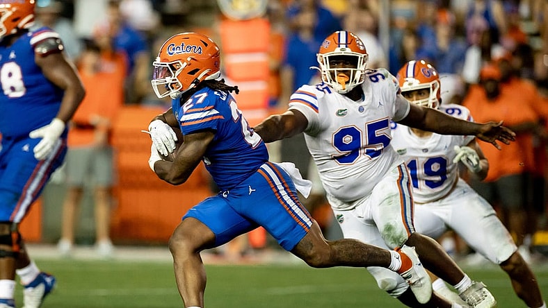 Florida Gators running back Cam Carroll (27) rushes past Florida Gators defensive lineman Jamari Lyons (95) during the second half during the Florida Gators Orange and Blue Spring Game at Steve Spurrier Field at Ben Hill Griffin Stadium in Gainesville, FL on Thursday, April 13, 2023. [Matt Pendleton/Gainesville Sun]

Ncaa Football Florida Gators Orange Blue Spring Game