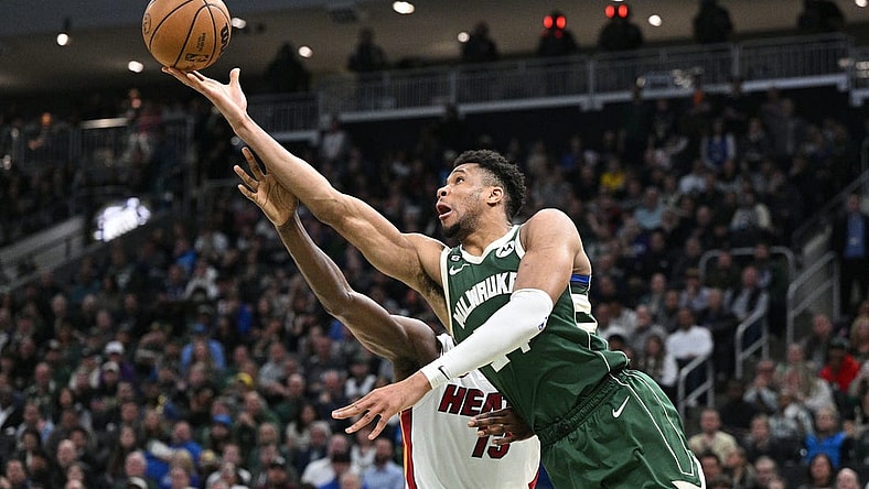 Apr 26, 2023; Milwaukee, Wisconsin, USA; Milwaukee Bucks forward Giannis Antetokounmpo (34) lays up a shot against Miami Heat center Bam Adebayo (13) during game five of the 2023 NBA Playoffs at Fiserv Forum. Mandatory Credit: Michael McLoone-USA TODAY Sports
