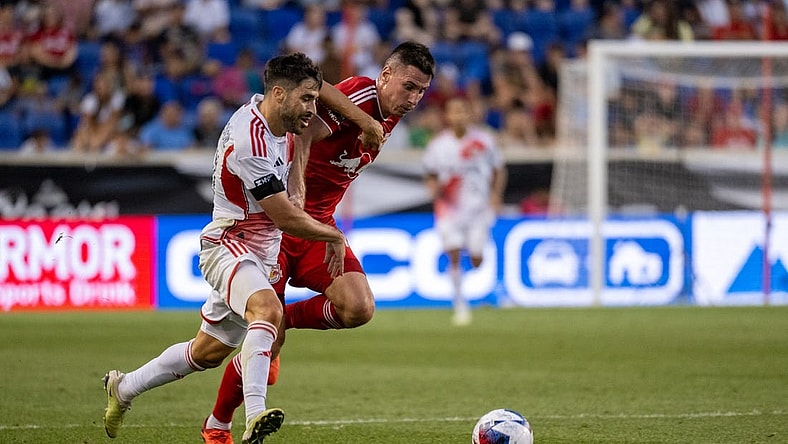 Jul 22, 2023; Harrison, NJ, USA; New England Revolution midfielder Carles Gil (10) fights for the ball against New York Red Bulls defender Sean Nealis (15) during the first half at Red Bull Arena. Mandatory Credit: Mark Smith-USA TODAY Sports