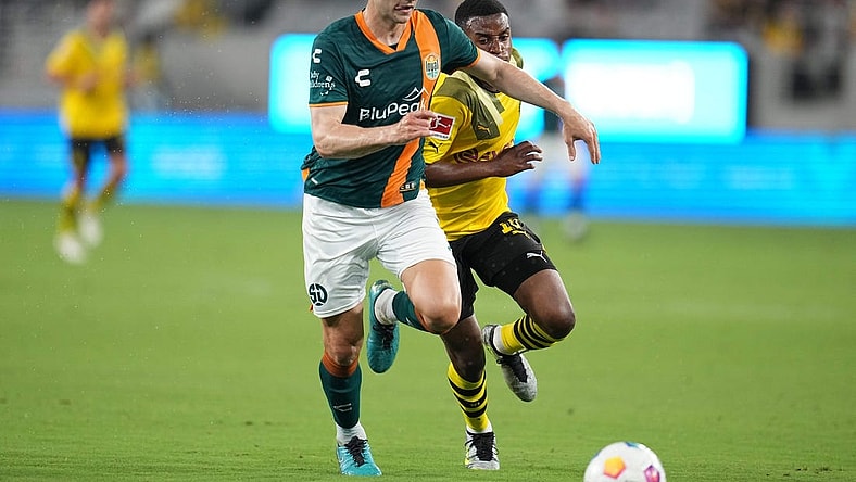 Jul 27, 2023; San Diego, California, USA;  San Diego Loyal defender Grant Stoneman (5) battles for the ball against Borussia Dortmund forward Youssoufa Moukoko (18) during the first half at Snapdragon Stadium. Mandatory Credit: Ray Acevedo-USA TODAY Sports