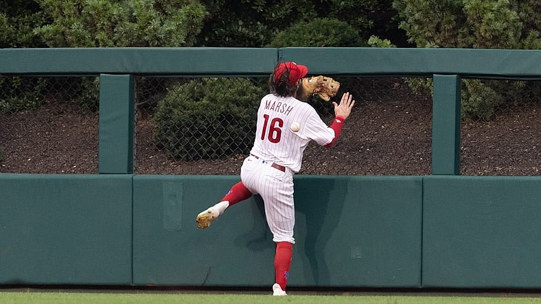 Aug 5, 2023; Philadelphia, Pennsylvania, USA; Philadelphia Phillies center fielder Brandon Marsh (16) is injured while attempting to catch the triple of Kansas City Royals second baseman Samad Taylor (not pictured) during the fifth inning at Citizens Bank Park. Mandatory Credit: Bill Streicher-USA TODAY Sports