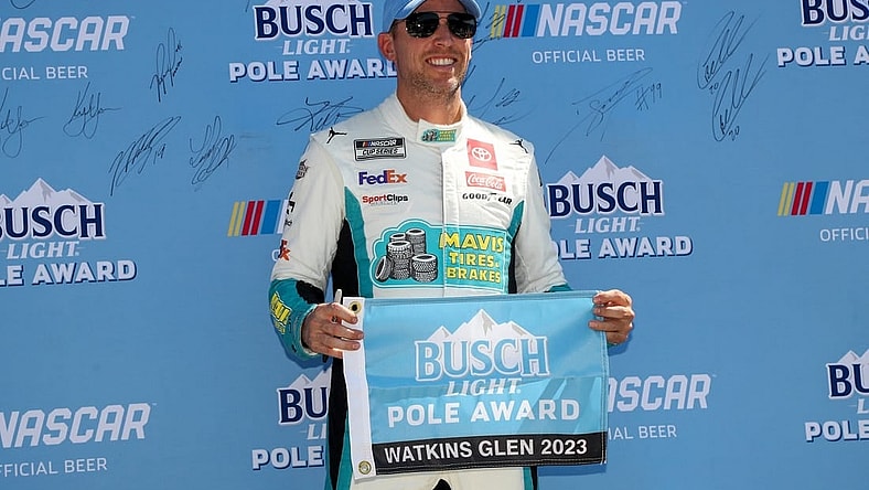 Aug 19, 2023; Watkins Glen, New York, USA; NASCAR Cup Series driver Denny Hamlin stands with the Busch Light Pole Award after winning the pole for the Go Bowling at The Glen at Watkins Glen International. Mandatory Credit: Matthew O'Haren-USA TODAY Sports