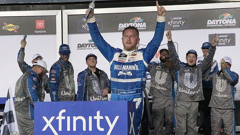 Justin Allgaier stands on his no. 7 Chevrolet in Victory Lane, Friday night August 25, 2023 after winning the Wawa 250 at Daytona International Speedway.