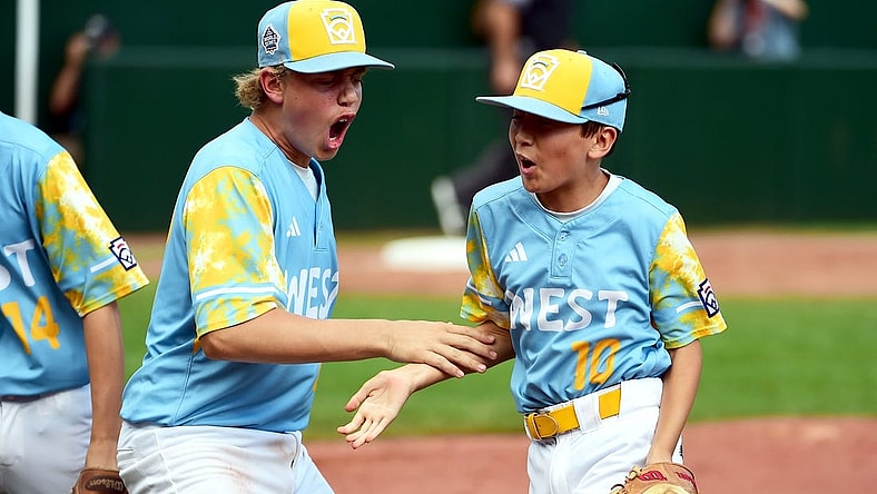 Aug 27, 2023; Williamsport, PA, USA; West Region second baseman Colby Lee (10) is congratulated by first baseman Jaxon Kalish (22) after turning a double play in the second inning against the Caribbean Region at Lamade Stadium. Mandatory Credit: Evan Habeeb-USA TODAY Sports