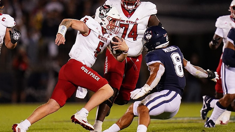 Aug 31, 2023; East Hartford, Connecticut, USA; North Carolina State Wolfpack quarterback Brennan Armstrong (5) runs the ball against UConn Huskies linebacker Jackson Mitchell (8) in the second quarter at Rentschler Field at Pratt & Whitney Stadium. Mandatory Credit: David Butler II-USA TODAY Sports