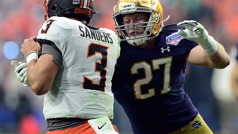 Jan 1, 2022; Glendale, Arizona, USA; Oklahoma State Cowboys quarterback Spencer Sanders (3) eludes the sack of Notre Dame Fighting Irish linebacker JD Bertrand (27) during the first half of the 2022 Fiesta Bowl at State Farm Stadium. Mandatory Credit: Joe Camporeale-USA TODAY Sports