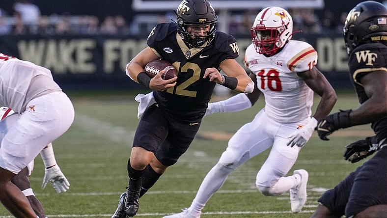 Sep 1, 2022; Winston-Salem, North Carolina, USA; Wake Forest Demon Deacons quarterback Mitch Griffis (12) runs past Virginia Military Institute Keydets linebacker Jason Johnson (18) during the first half at Truist Field. Mandatory Credit: Jim Dedmon-USA TODAY Sports