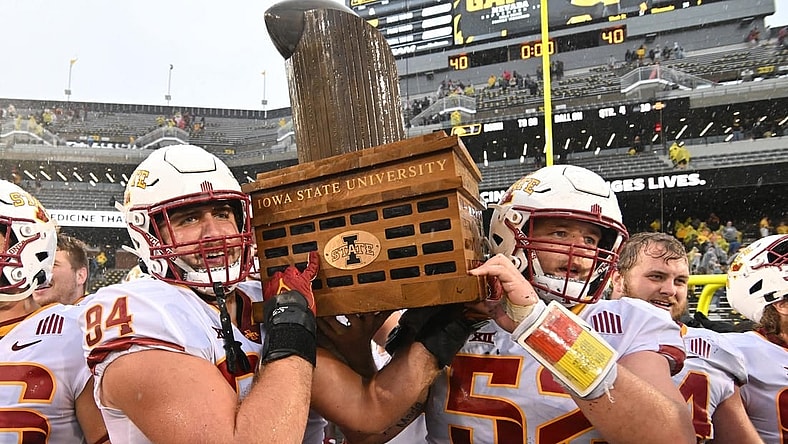 Sep 10, 2022; Iowa City, Iowa, USA; Iowa State Cyclones defensive lineman Kyle Krezek (94) and offensive lineman Trevor Downing (52) carry the Cy-Hawk trophy after the game against the Iowa Hawkeyes at Kinnick Stadium. Mandatory Credit: Jeffrey Becker-USA TODAY Sports