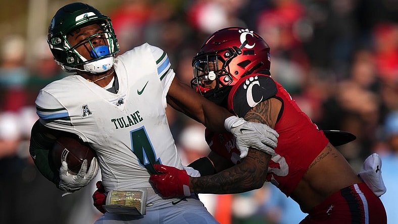 Nov. 25, 2022; Cincinnati, Ohio, USA; Cincinnati Bearcats linebacker Deshawn Pace (20) tackles Tulane Green Wave wide receiver Jha'Quan Jackson (4) on a punt return in the fourth quarter during a college football game, Friday, Nov. 25, 2022, at Nippert Stadium in Cincinnati.