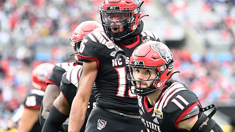 Dec 30, 2022; Charlotte, NC, USA; North Carolina State Wolfpack safety Rakeim Ashford (16) reacts with linebacker Payton Wilson (11) after intercepting the ball in the fourth quarter in the 2022 Duke's Mayo Bowl at Bank of America Stadium. Mandatory Credit: Bob Donnan-USA TODAY Sports