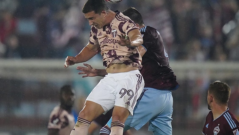 Jul 4, 2023; Commerce City, Colorado, USA; Portland Timbers forward Nathan Fogaca (99) heads the ball against Colorado Rapids defender Danny Wilson (4) during the first half at Dick's Sporting Goods Park. Mandatory Credit: Ron Chenoy-USA TODAY Sports