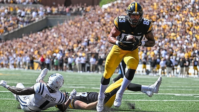 Sep 2, 2023; Iowa City, Iowa, USA; Iowa Hawkeyes tight end Erick All (83) scores on a touchdown pass as Utah State Aggies safety Anthony Switzer (1) and Iowa tight end Steven Stilianos (86) lay on the turf during the first quarter at Kinnick Stadium. Mandatory Credit: Jeffrey Becker-USA TODAY Sports