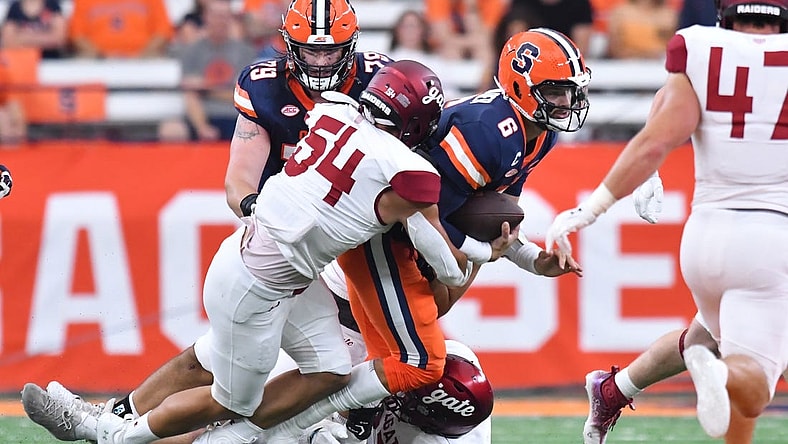 Sep 2, 2023; Syracuse, New York, USA; Syracuse Orange quarterback Garrett Shrader (6) is tackled by Colgate Raiders linebacker Christian Sweeney (54) in the first quarter at JMA Wireless Dome. Mandatory Credit: Mark Konezny-USA TODAY Sports