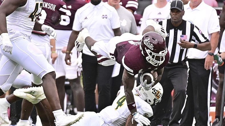 Sep 2, 2023; Starkville, Mississippi, USA; Mississippi State Bulldogs running back Jo'Quavious Marks (7) dives over Southeastern Louisiana Lions defensive back Ian Goodly (4) during the second quarter at Davis Wade Stadium at Scott Field. Mandatory Credit: Matt Bush-USA TODAY Sports